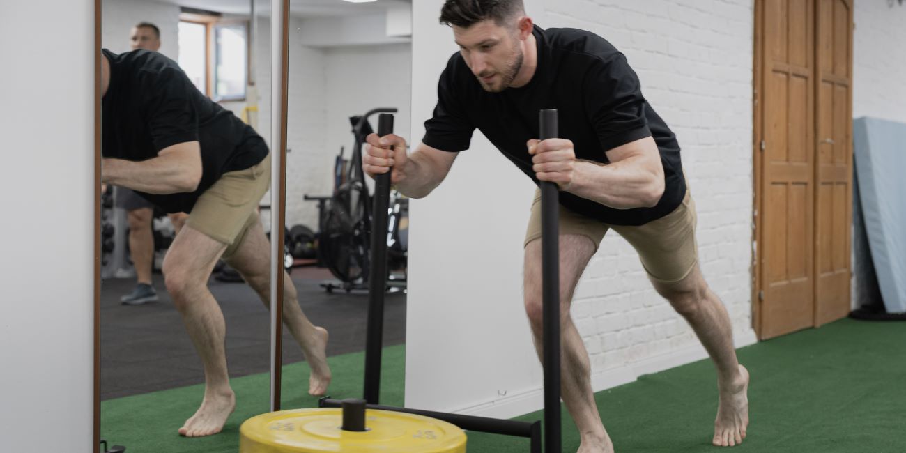 Sportoló szánt tol műfüvön erőnléti edzésen a PiroskaGymben, Bükön.