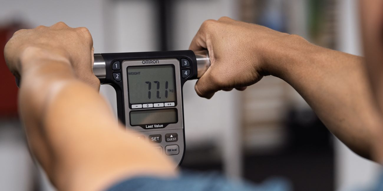 Omron testösszetétel-mérő kijelzője kézben, súlymérés a PiroskaGymben Bükön.